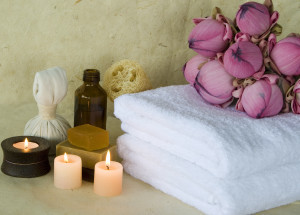 Spa products massage oil with candles and soap with Lotus flowers with background of handmade paper